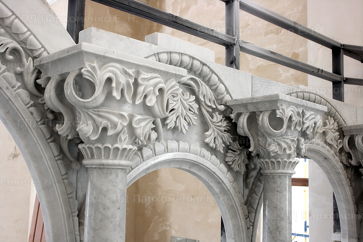 Высокий иконостас из белого мрамора в процессе монтажа